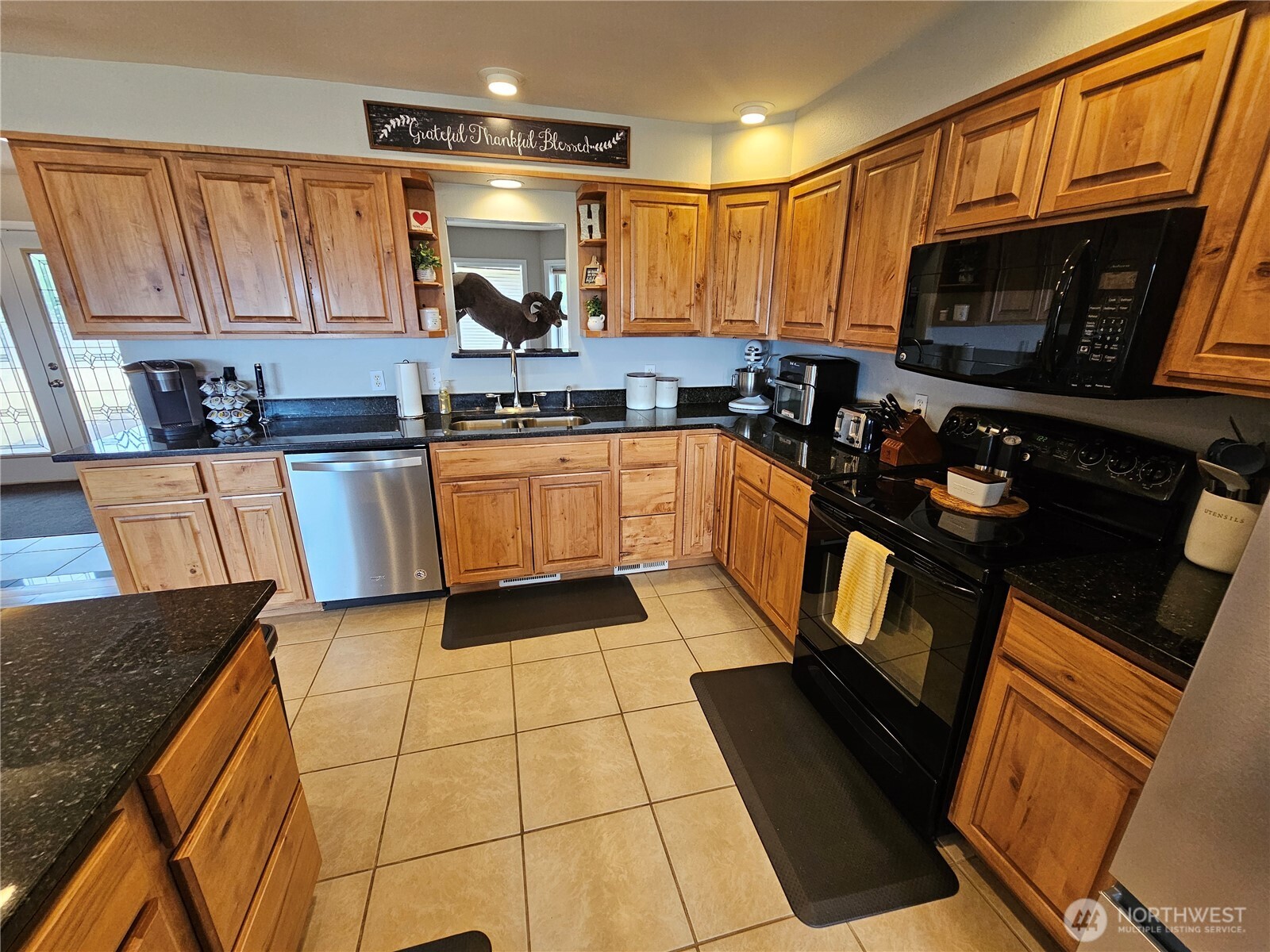 711 Havillah Road Tonasket, WA 98855 - Photo 10 of 40 a kitchen with granite countertop a sink a stove top oven a granite counter space and cabinets