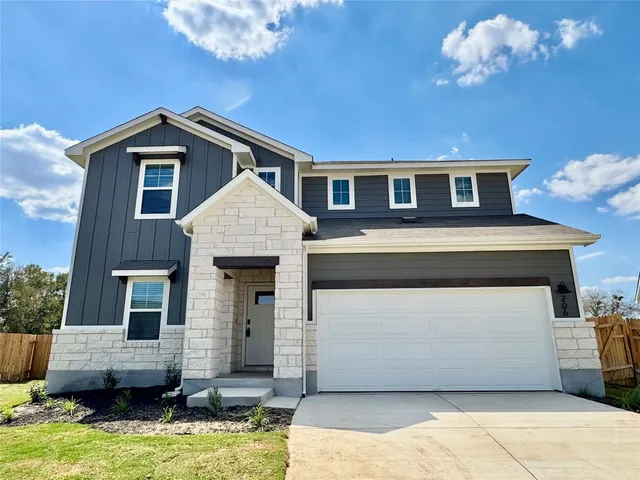 a front view of a house with yard garage and outdoor seating