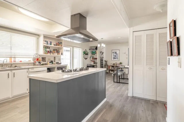 a kitchen with stainless steel appliances a sink a stove a refrigerator and cabinets