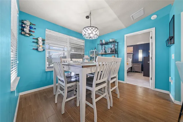 a view of a dining room with furniture wooden floor and a chandelier