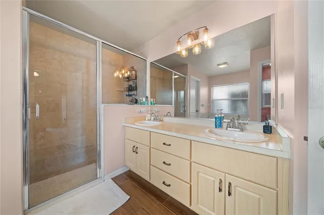 a bathroom with a double vanity sink mirror and shower