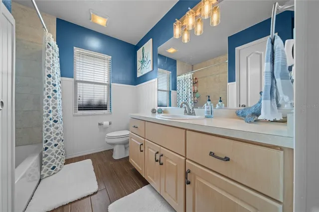 a spacious bathroom with double vanity a toilet a and a window