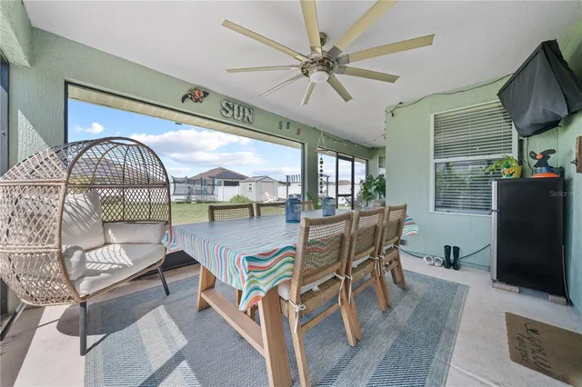 a living room with furniture a flat screen tv and a floor to ceiling window