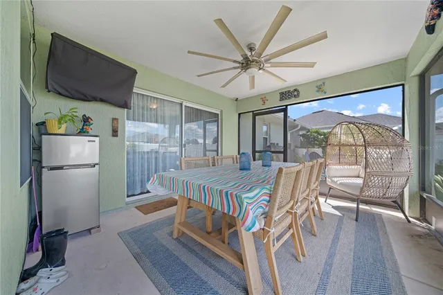 a living room with furniture a flat screen tv and a floor to ceiling window