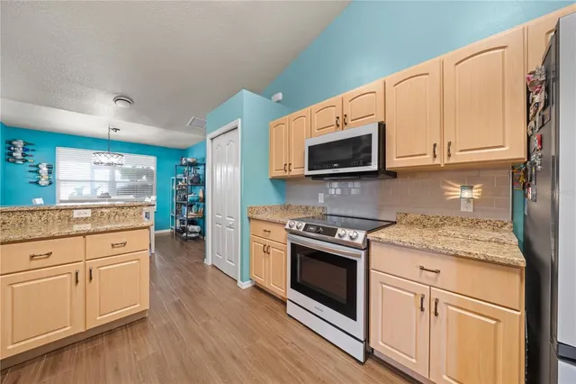 a kitchen with stainless steel appliances granite countertop a stove a sink and a microwave