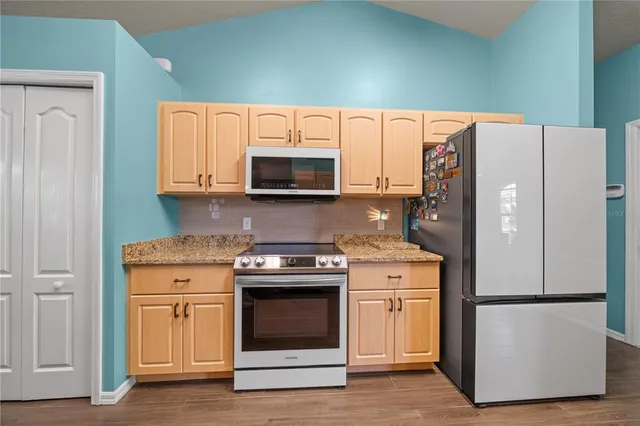 a kitchen with a stove top oven microwave and a refrigerator