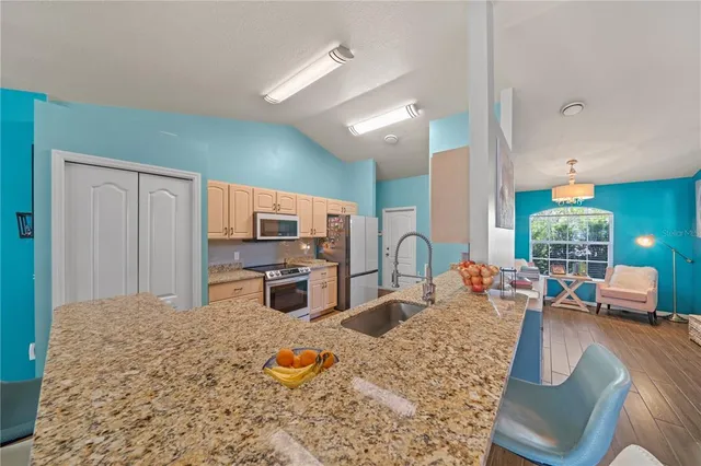 a kitchen with stainless steel appliances granite countertop a sink stove and refrigerator