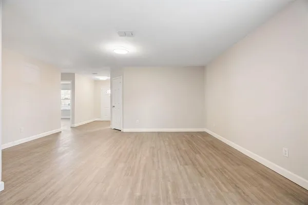 a view of an empty room with wooden floor