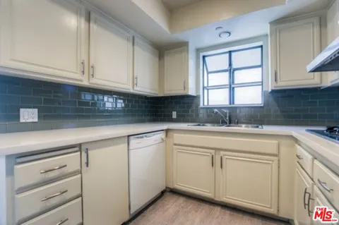 a kitchen with white cabinets and white appliances