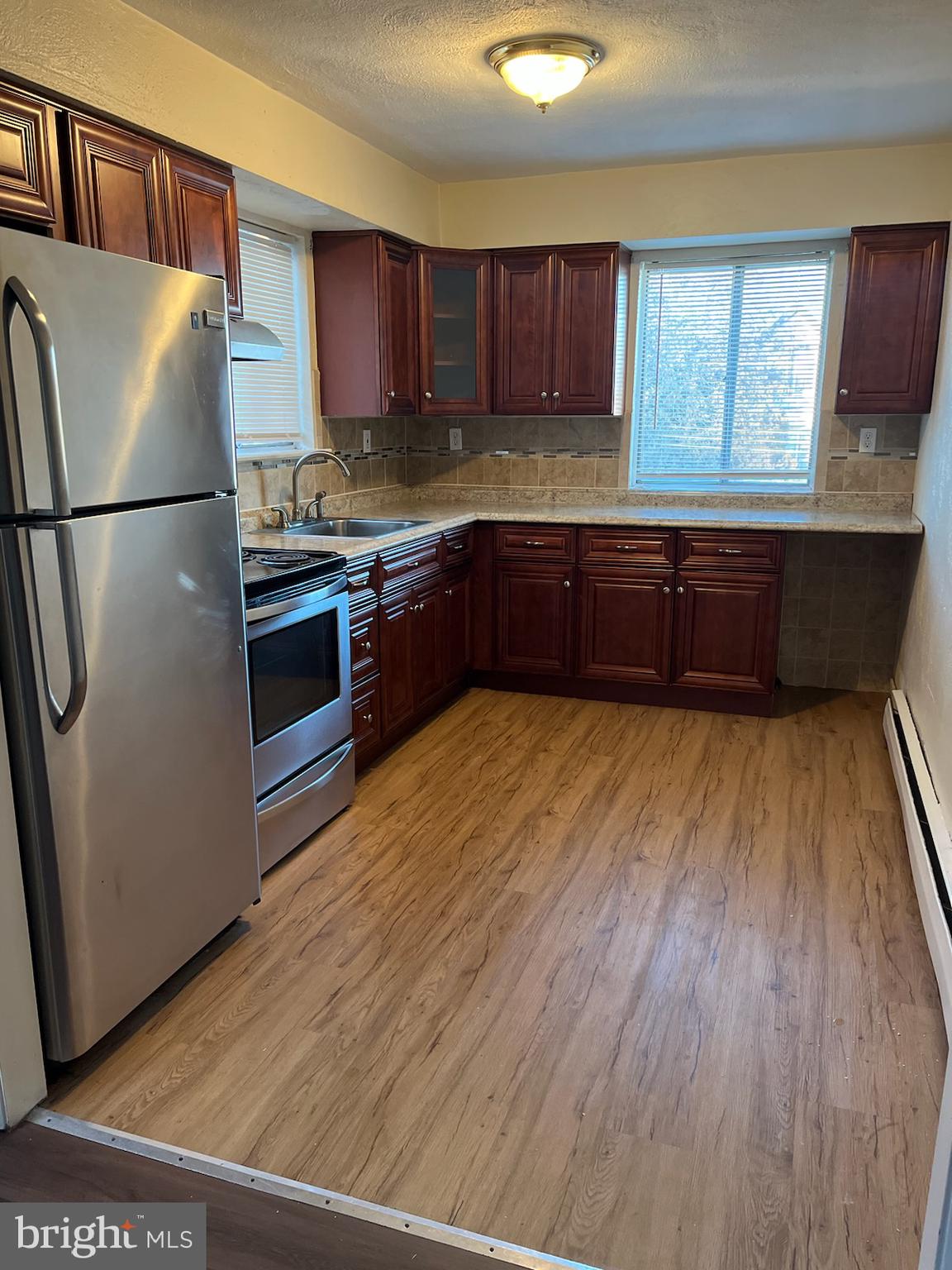 216 Boro Road, Unit A Secane, PA 19018 - Photo 11 of 14 a kitchen with granite countertop wooden floors stainless steel appliances a sink and a window