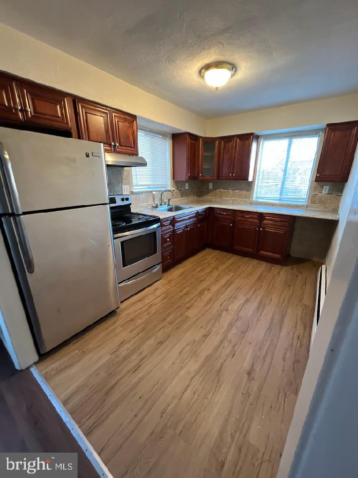 216 Boro Road, Unit A Secane, PA 19018 - Photo 13 of 14 a kitchen with stainless steel appliances granite countertop a refrigerator a sink and a stove