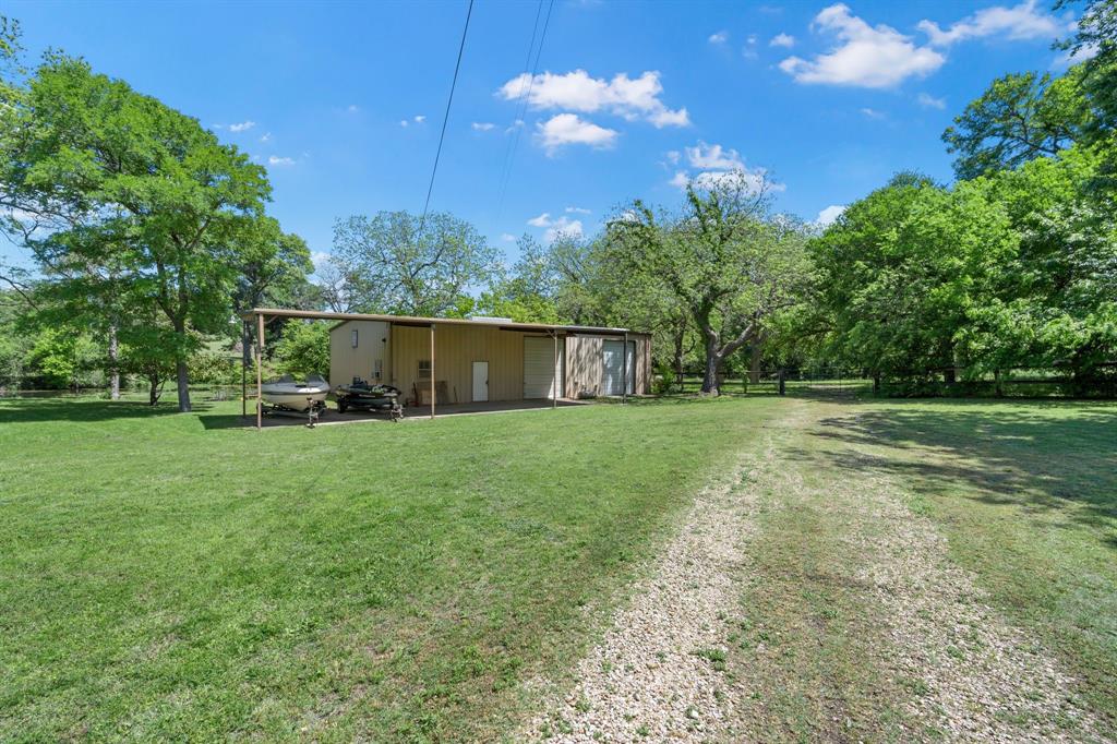 3231 Plainview Road Midlothian, TX 76065 - Photo 4 of 22 a view of a backyard with table and chairs plants and large tree