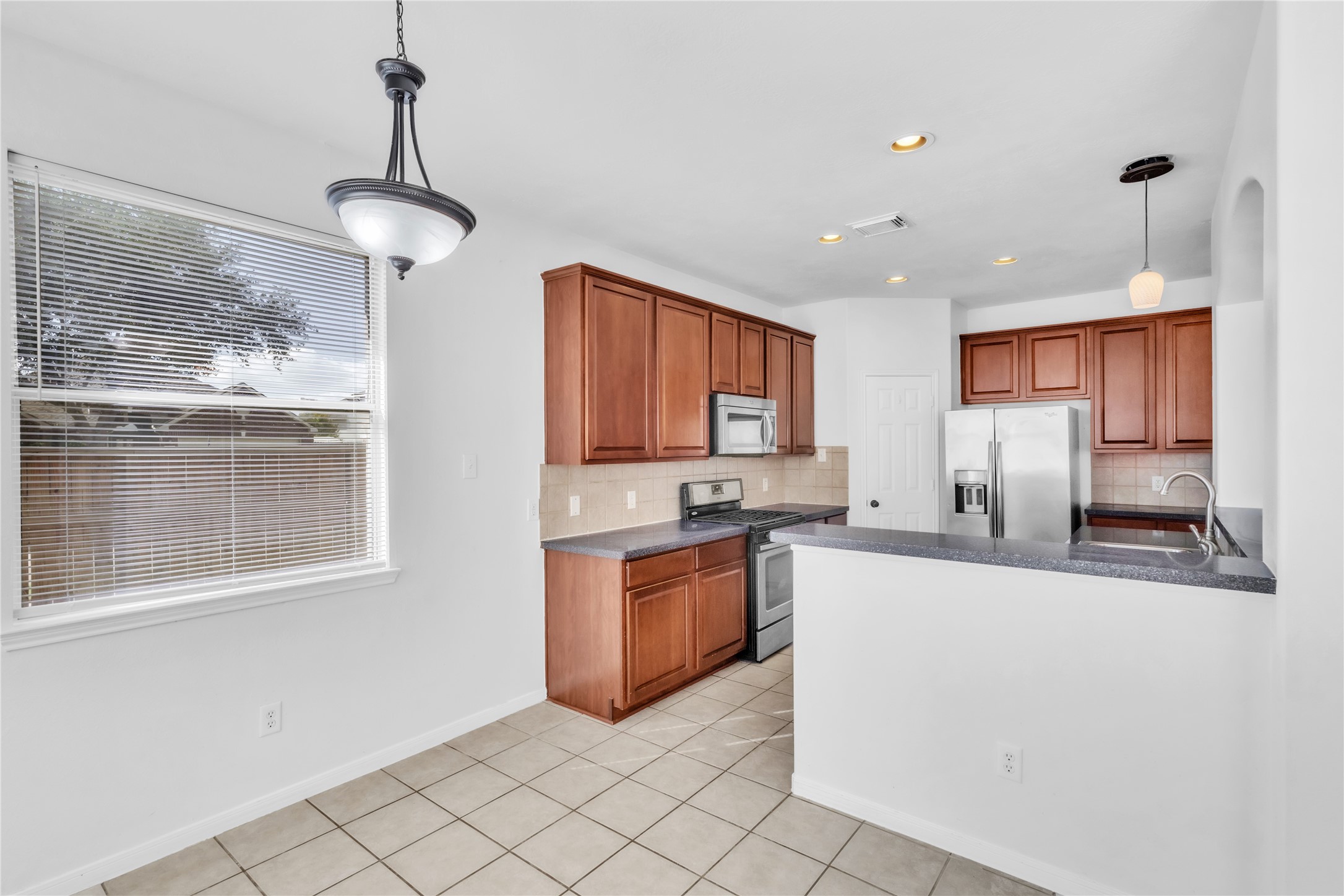 18027 Oak Orchard Lane Cypress, TX 77433 - Photo 13 of 37 a kitchen with stainless steel appliances granite countertop a sink a stove and a refrigerator