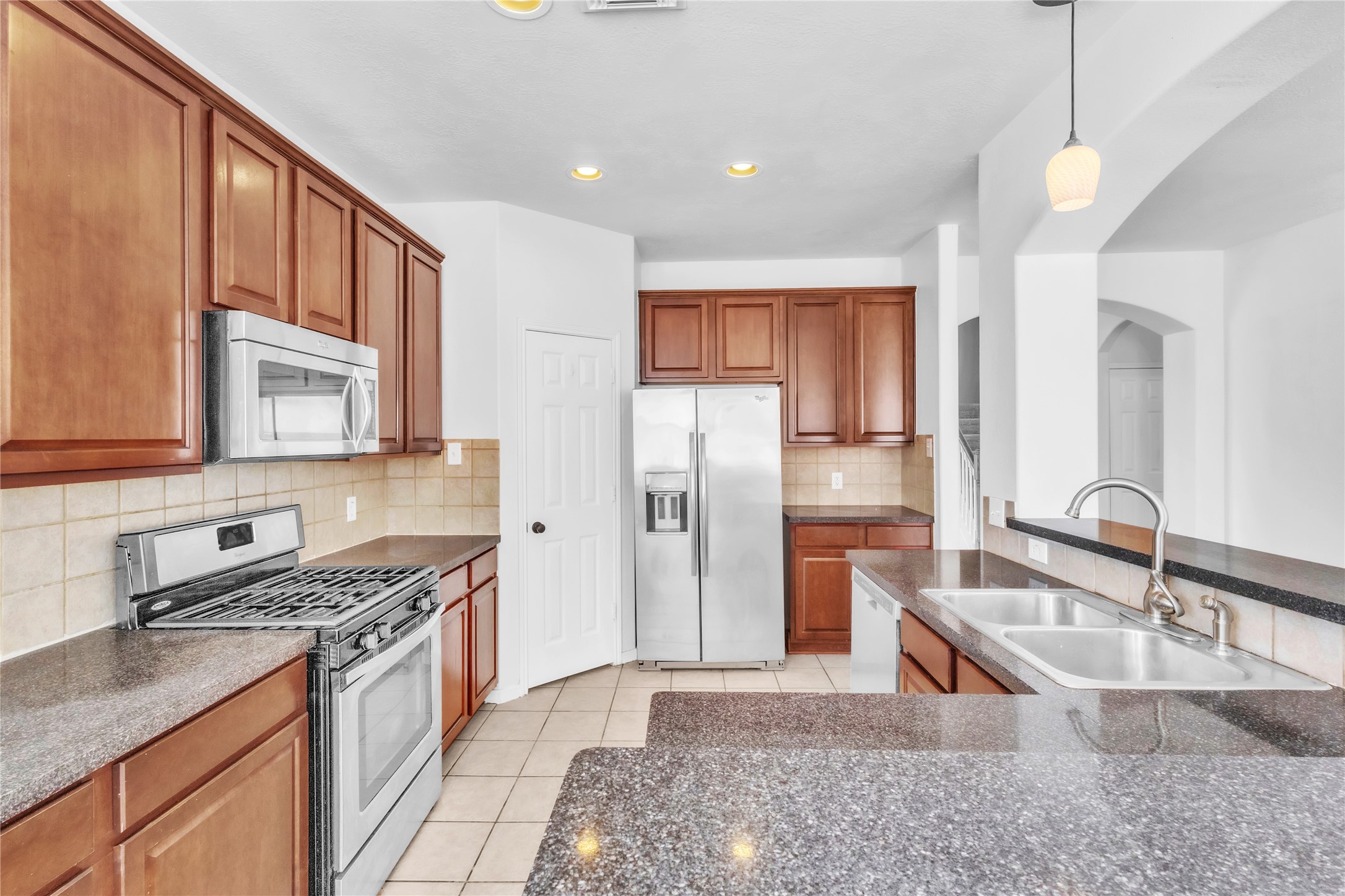 18027 Oak Orchard Lane Cypress, TX 77433 - Photo 15 of 37 a kitchen with stainless steel appliances granite countertop a sink stove and refrigerator