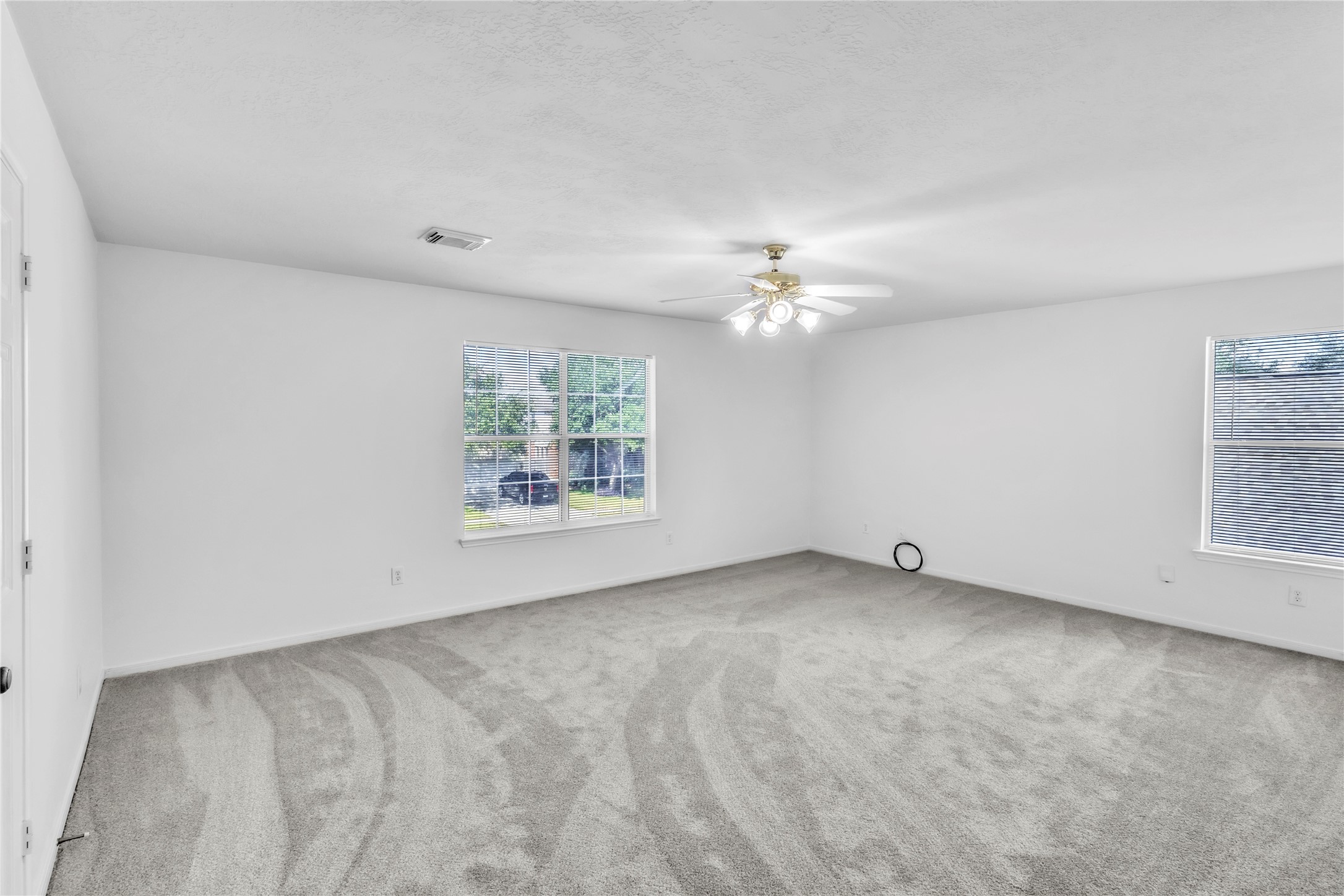 18027 Oak Orchard Lane Cypress, TX 77433 - Photo 33 of 37 an empty room with windows and chandelier fan