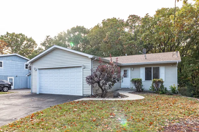 a front view of house with yard and trees in the background