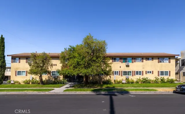 a view of a big house with a big yard and palm trees