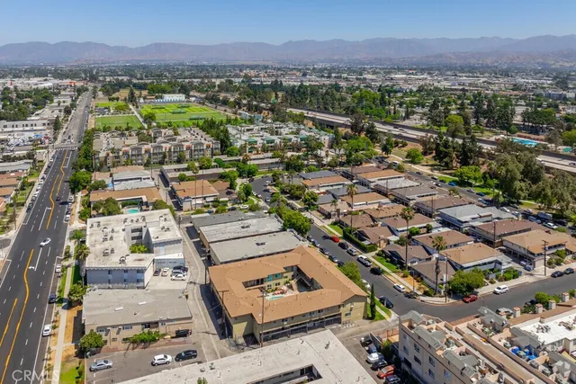 an aerial view of a city with lots of residential buildings and mountain view in back