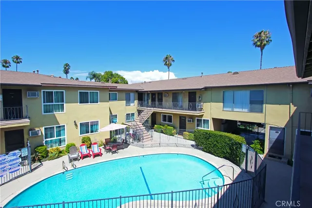 a view of a house with pool and chairs