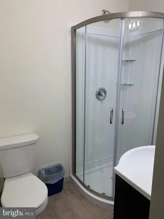 a white toilet sitting next to a shower