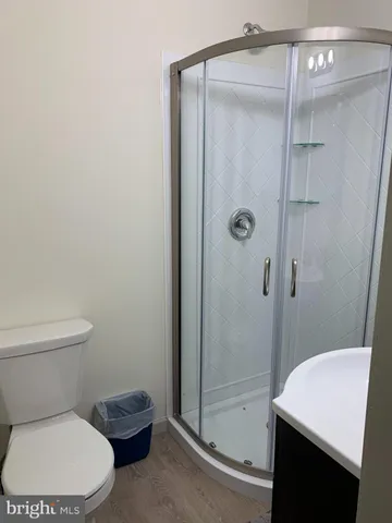 a white toilet sitting next to a shower