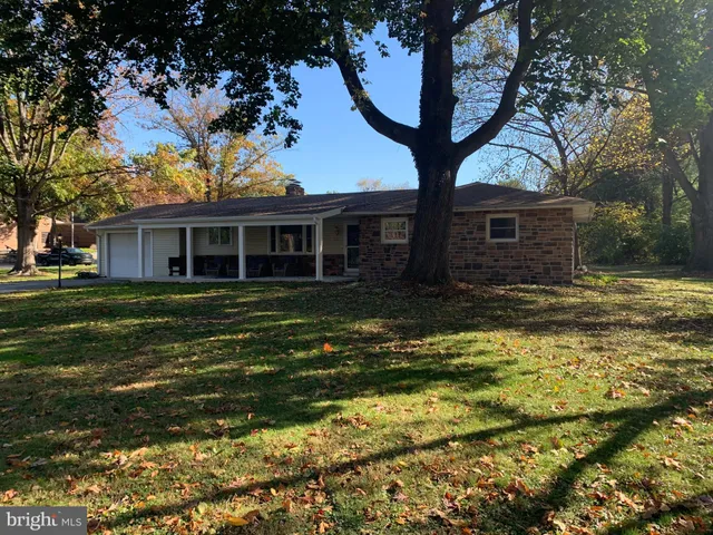 a view of a house with a yard and large tree