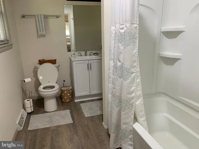 a bathroom with a tub sink and mirror