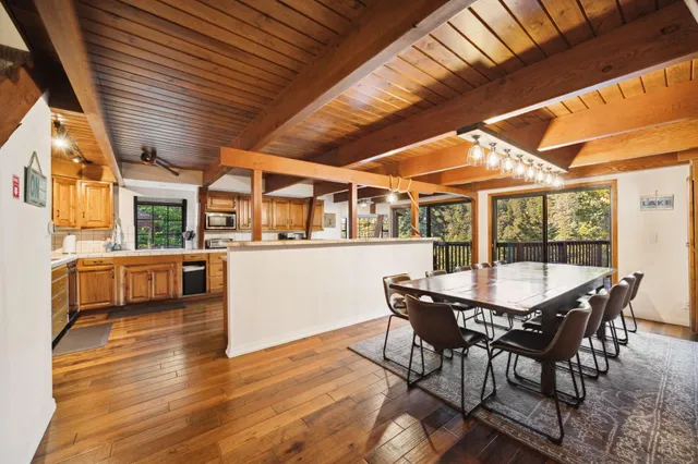 a kitchen with stainless steel appliances granite countertop a refrigerator a oven and white cabinets with wooden floors