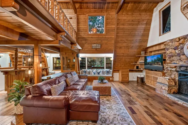 a view of a patio with table and chairs under an umbrella with wooden floor and fence
