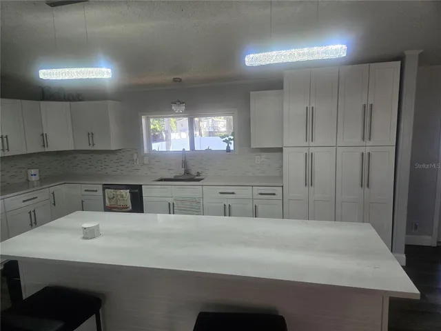 a kitchen with stainless steel appliances granite countertop a sink a stove and a refrigerator