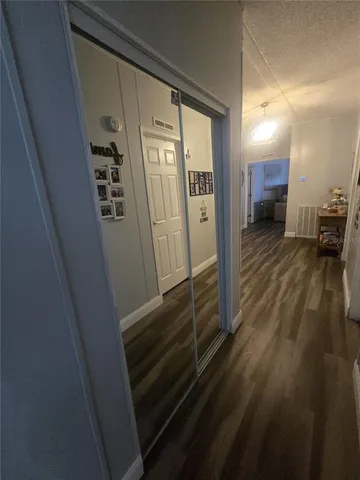 a view of a hallway with wooden floor and furniture