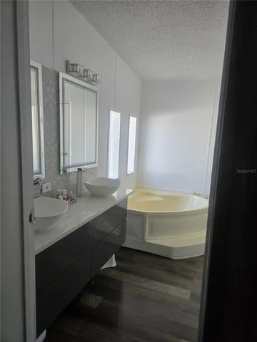 a bathroom with a tub sink and mirror