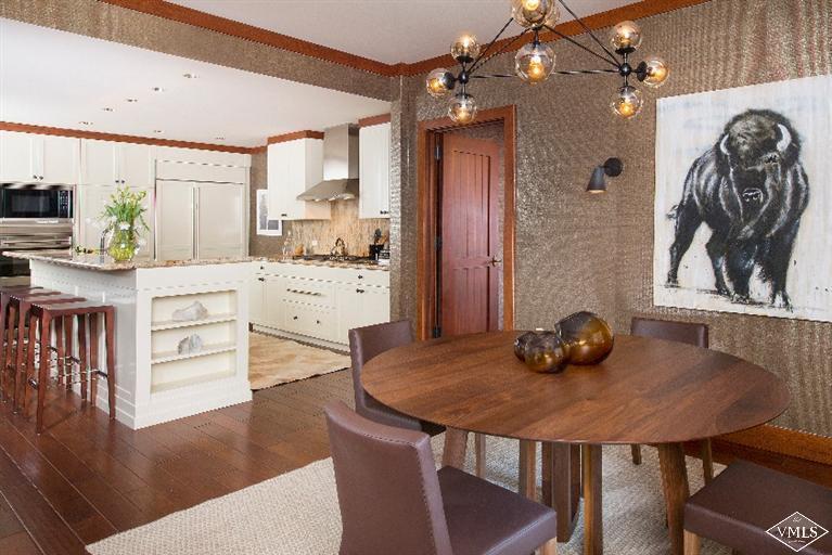 1 Vail Road, Unit 7203 Vail, CO 81657 - Photo 5 of 16 a kitchen with a table chairs and cabinets