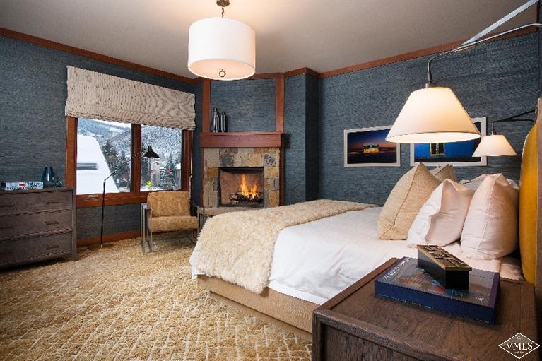 1 Vail Road, Unit 7203 Vail, CO 81657 - Photo 10 of 16 a bedroom with a bed and a fireplace
