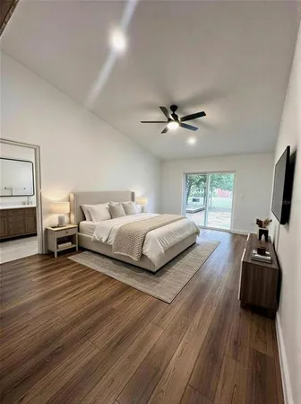 a bedroom with a bed a couch and a flat tv screen on dresser