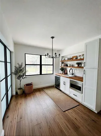 a kitchen with stainless steel appliances a stove and a wooden floor