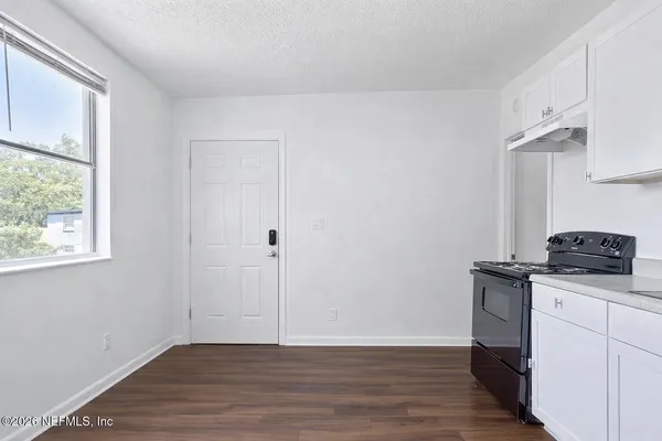 a view of a kitchen with wooden floor and electronic appliances