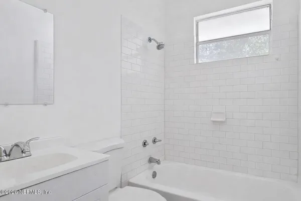 a bathroom with a toilet a sink a mirror and a bathtub