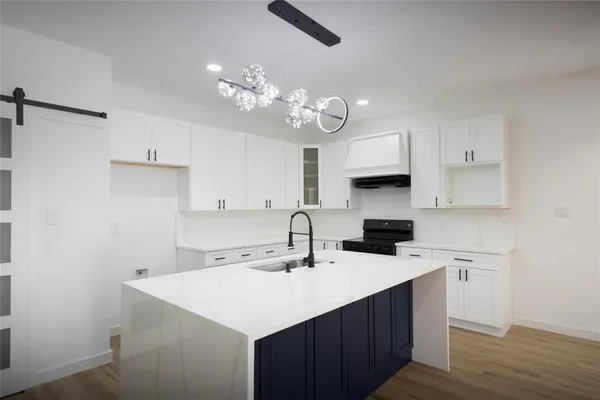 a kitchen with a sink a stove a microwave and cabinets