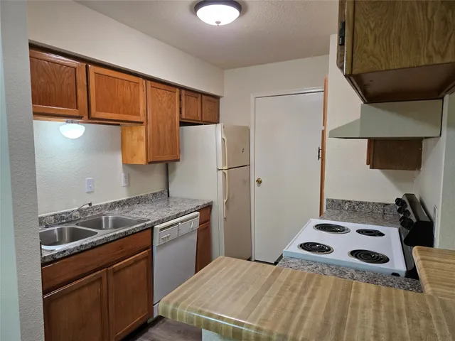 a kitchen with a stove a refrigerator and a sink