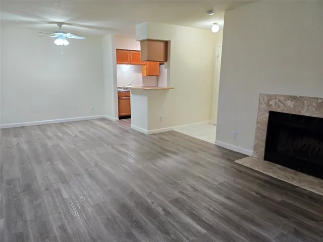 an empty room with wooden floor and fireplace