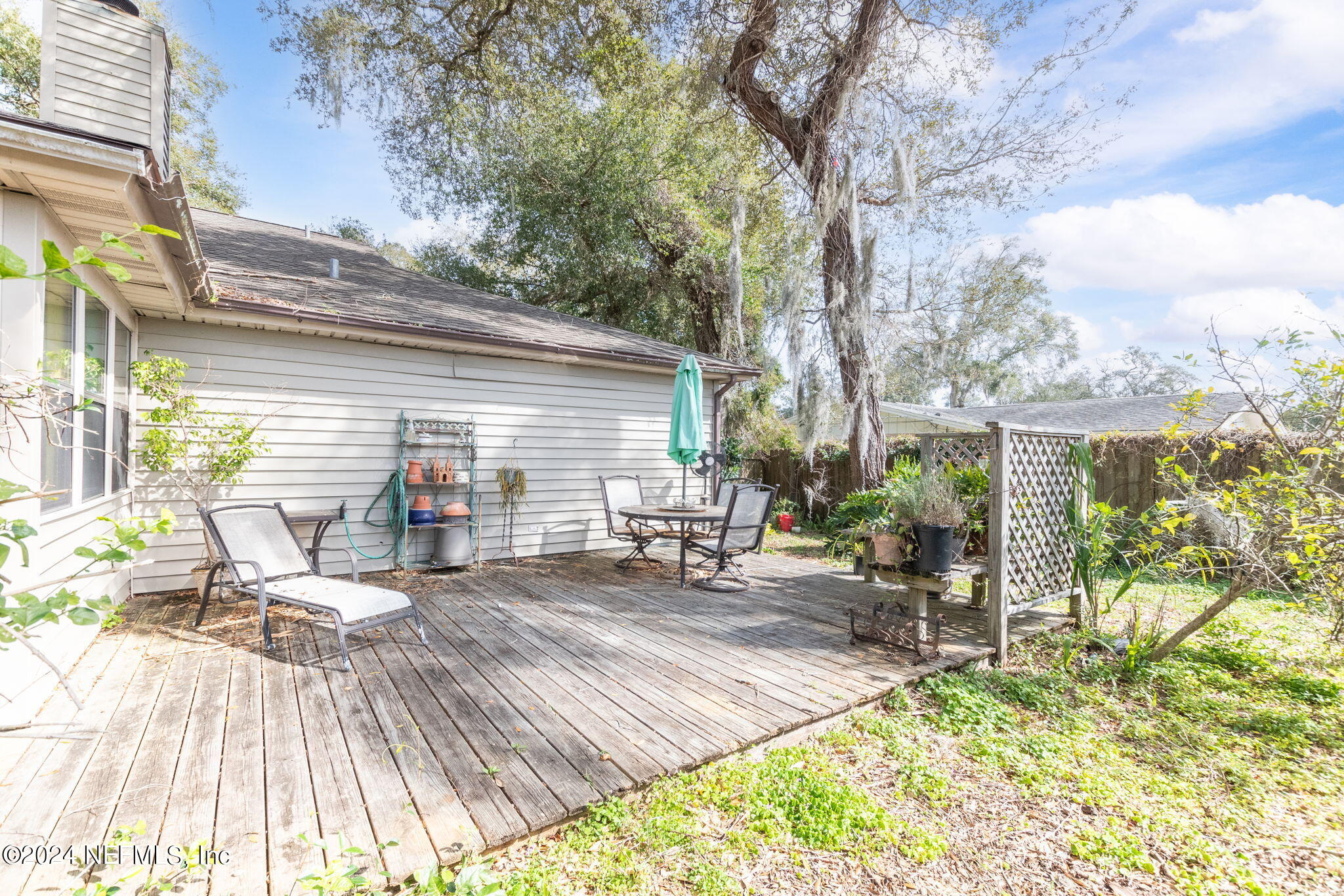 312 Linden Road St. Augustine, FL 32086 - Photo 25 of 40 a view of a patio with table and chairs with wooden floor and fence