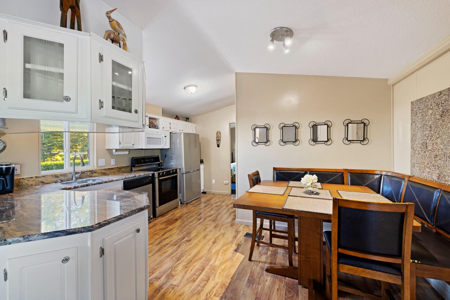 10675 Valensin Road Galt, CA 95632 - Photo 57 of 99 a kitchen with stainless steel appliances kitchen island granite countertop a dining table chairs and a refrigerator