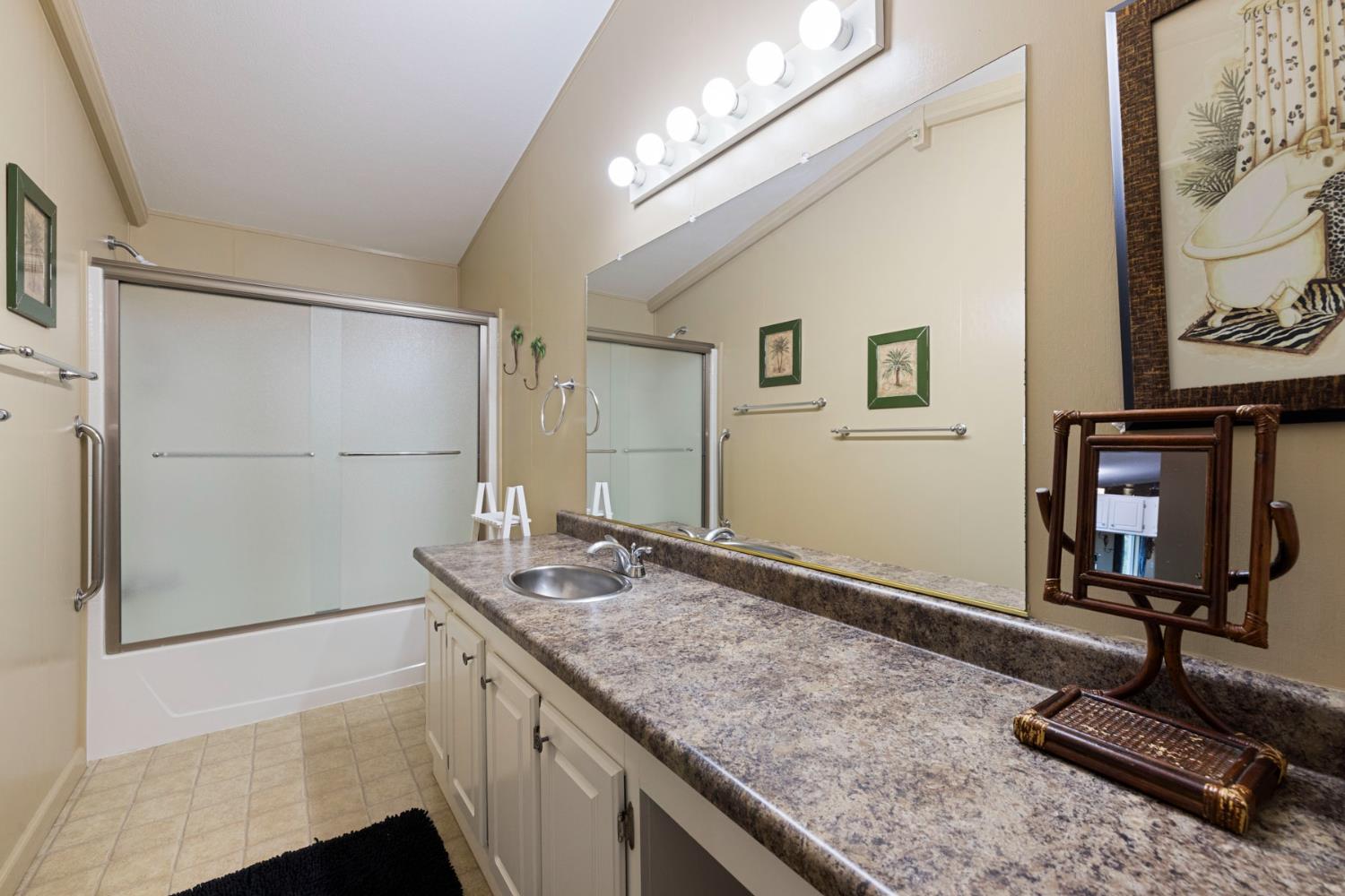 10675 Valensin Road Galt, CA 95632 - Photo 63 of 99 a bathroom with a granite countertop sink a mirror and a shower