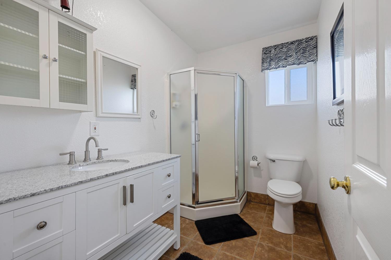 10675 Valensin Road Galt, CA 95632 - Photo 68 of 99 a spacious bathroom with a granite countertop sink toilet and shower