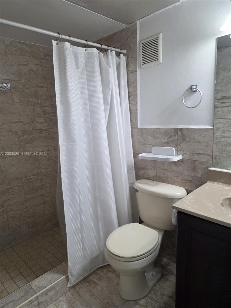 23231 Southwest 129th Path Homestead, FL 33032 - Photo 33 of 33 a white toilet sitting next to a shower curtain