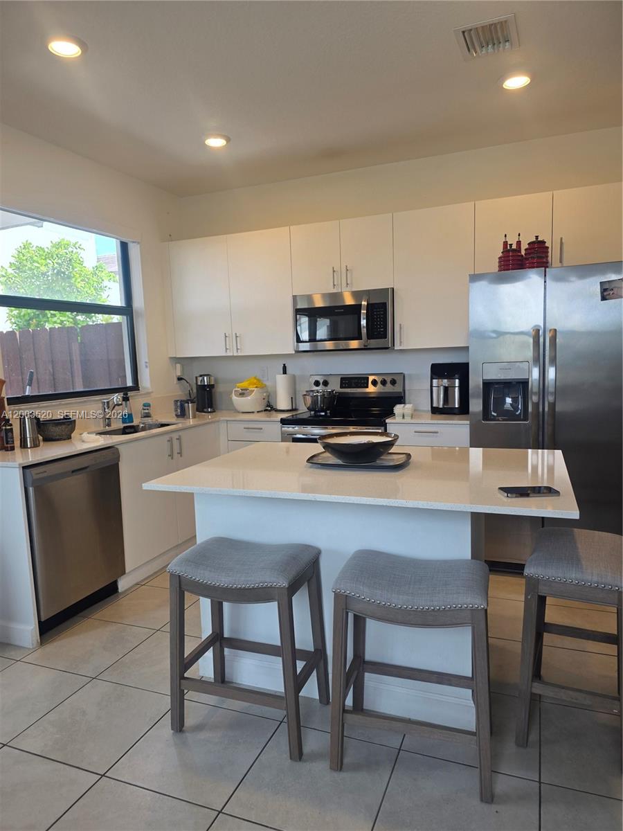 23231 Southwest 129th Path Homestead, FL 33032 - Photo 5 of 33 a kitchen with a sink a counter top space appliances and cabinets