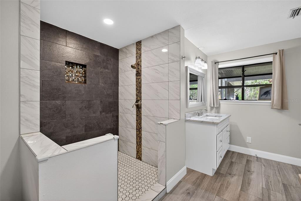 182 Parsons Road Longwood, FL 32779 - Photo 12 of 54 a bathroom with a granite countertop sink a shower and a mirror