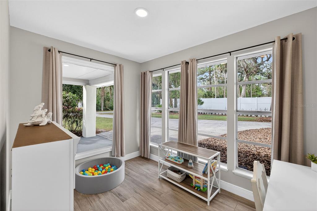 182 Parsons Road Longwood, FL 32779 - Photo 23 of 54 a living room with a couch and a dining table with garden view