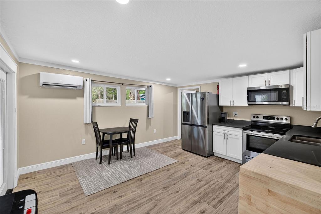 182 Parsons Road Longwood, FL 32779 - Photo 32 of 54 a kitchen with stainless steel appliances granite countertop a refrigerator a stove top oven a sink dishwasher a dining table and chairs with wooden floor